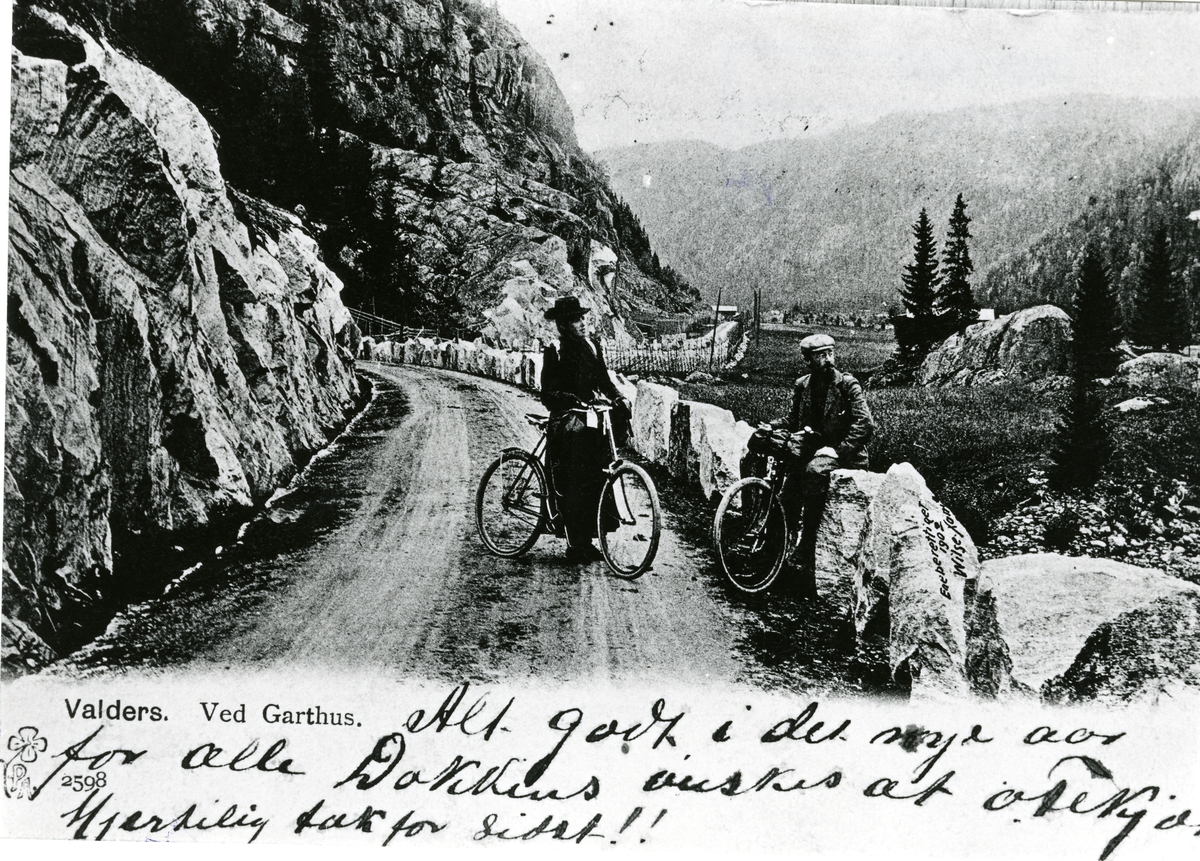 En kvinne og en mann avbildet med hver sin sykkel ved Garthus i Sør-Aurdal.