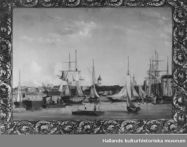 Oljemålning på plåt med förgylld träram. Föreställer Varbergs hamn med där liggande båtar, i bakgrunden staden med dess byggnader. 