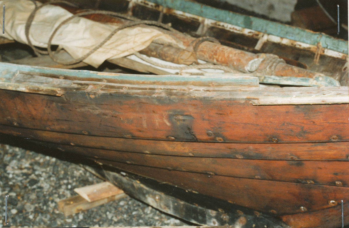 Tjørebrædd med grønmala rip. Ulike reparasjoner langs ripa. Reparert styre, ein del nye tiljer. Årar og båtrip er merka "L.B.Pilskog".