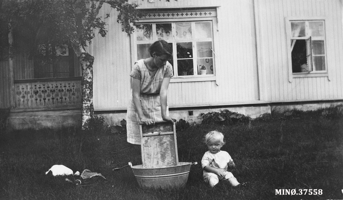 Kvinne med vaskebrett, lite barn. klesvask ved Steien Hotell, Embret Mellesmo jr.