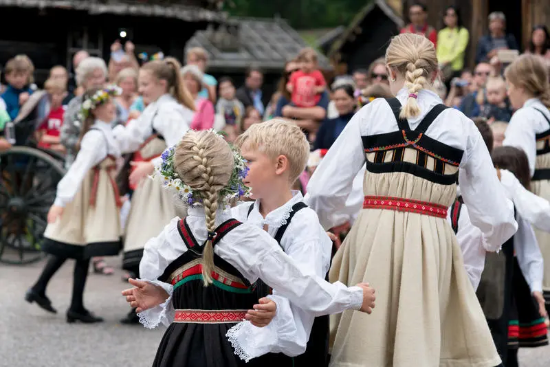 Barn i bunad danser folkedans.