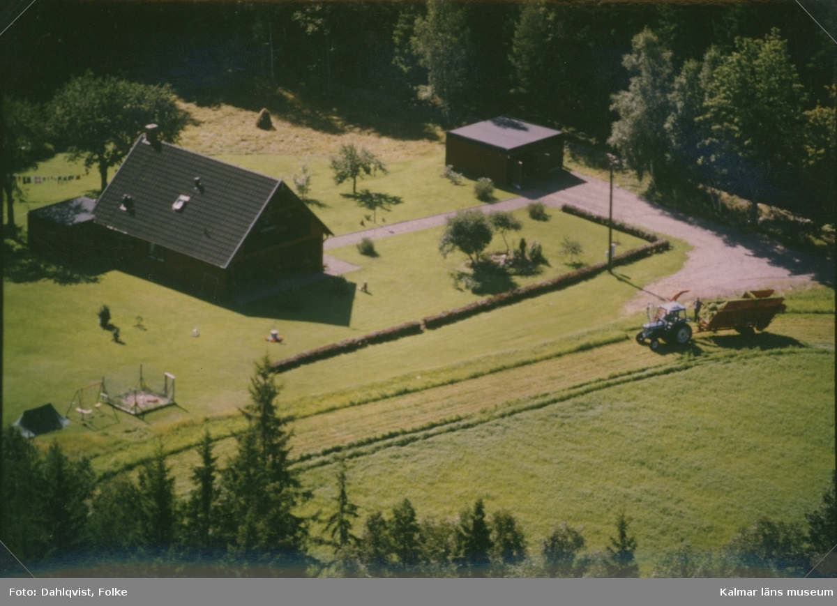 En villa med garage och en traktor med vagn i Madesjö socken.