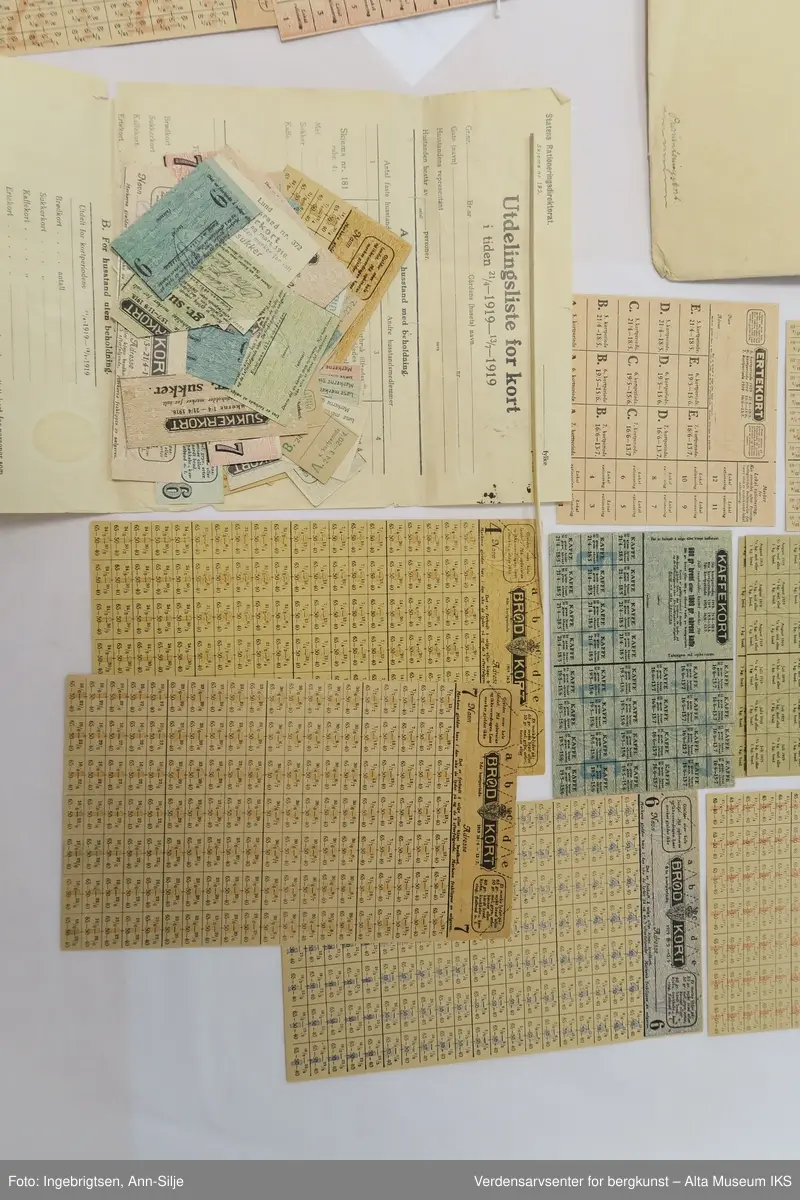 Konvolutt med mange rasjoneringskort. Det er kort for blant annet brød, erter, kaffe og sukker.