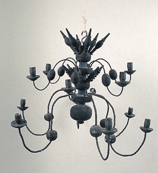 Svartmålad ljuskrona av trä med 12 ljusarmar av järn. Ljushållare av trä.
Enligt uppgift i arkivet har kronan följt med Härjevadskyrkan till Fornbyn i Skara.

Kronan togs in till samlingarna 2002 och ersattes med nytillverkad.