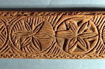 Mangelbräde med handtag och skuren dekor i form av rosetter. Märkt "A", "EIS" och "ANO 1784".