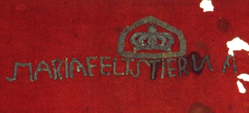 Antependium av brunrött ylletyg. Monogram, "MARIA FELTSTIERNA" formad av silverband. Över monogrammet finns en reliefbroderad krona inom en ram av silverband. Mycket trasig och sliten.