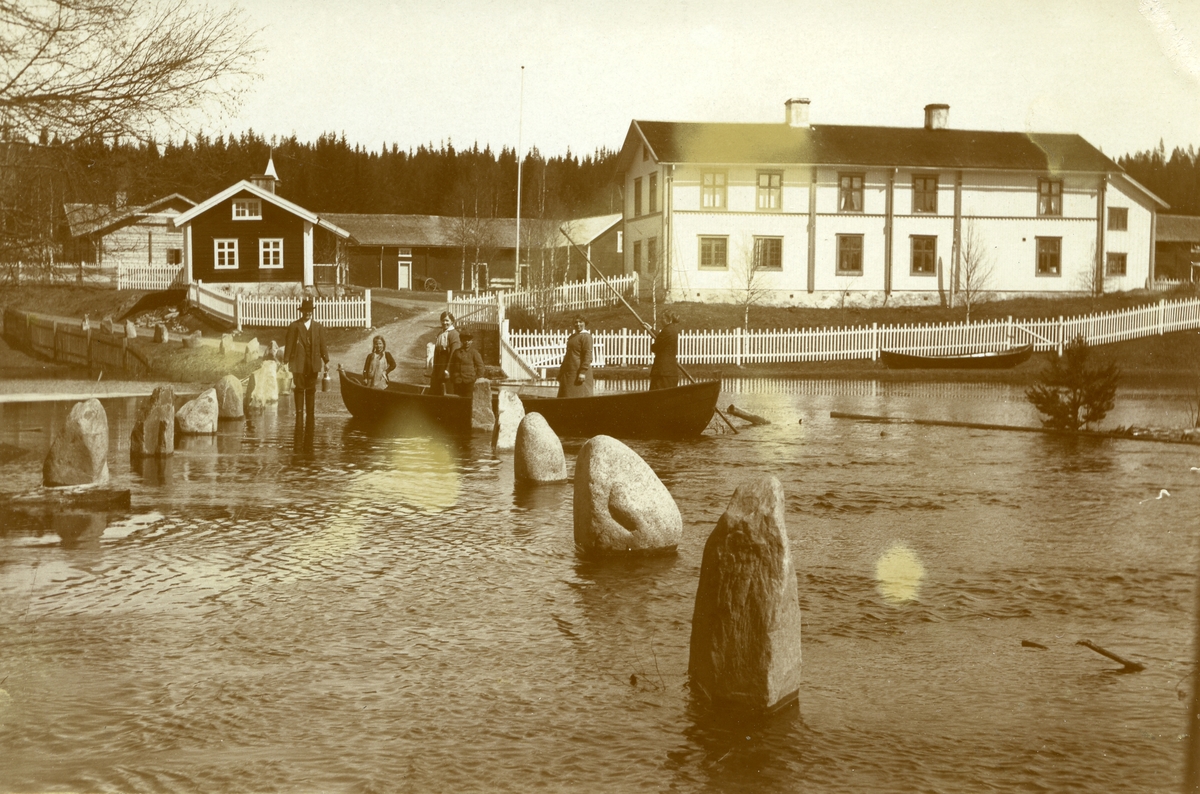 Storflommen i 1913 i Plassen. Båt med mennesker midt i bildet. Gard: Søndre Grønneset i bakgrunnen.