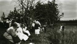 Presten og en av de døpte på vei opp fra vannet i Älvdalens 