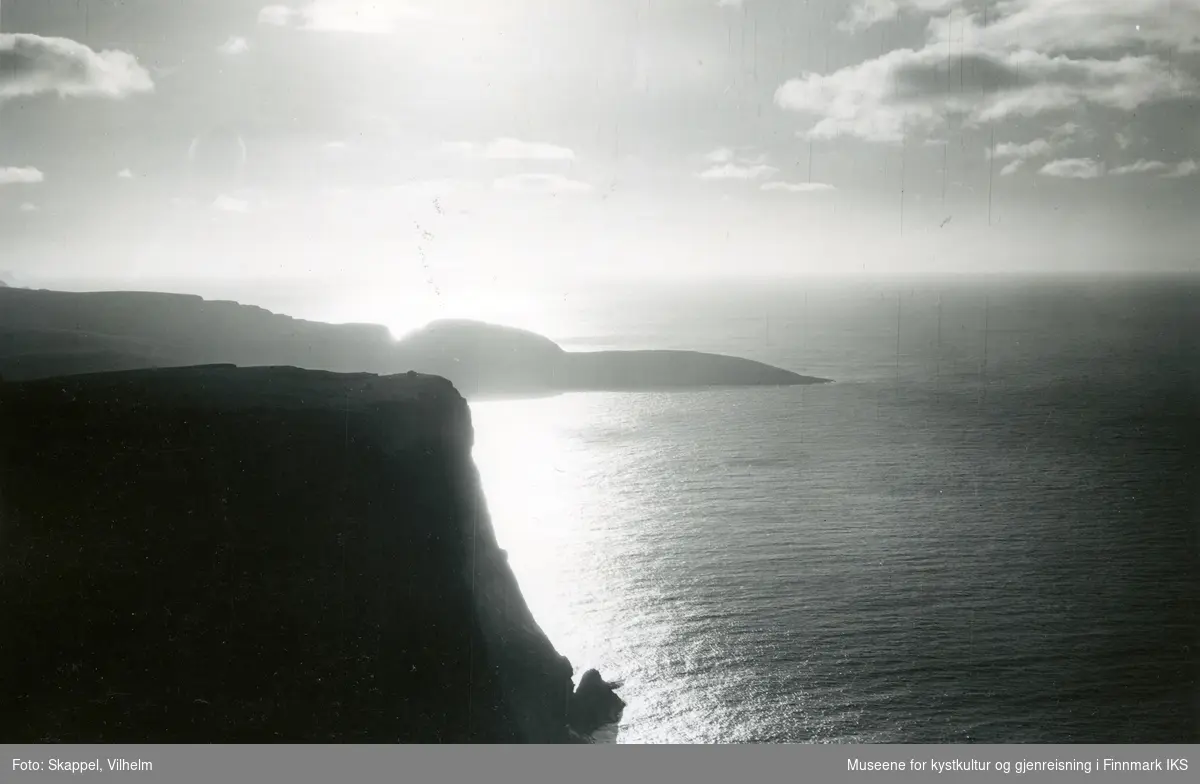 Flyfoto. Silhuett av Nordkapp-klippen. Knivskjellodden i bakgrunnen. 22.08.1953, kl 17.30.