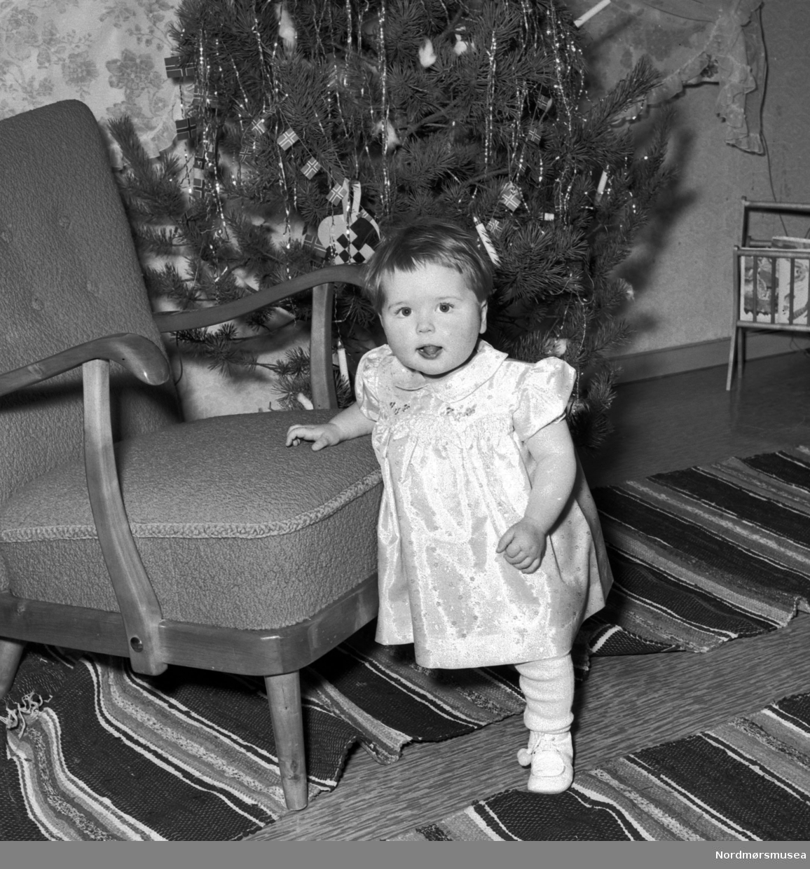 En liten jente foran et juletre. 
Fra Nordmøre museum sin fotosamling, Williamsarkivet. EFR2015
