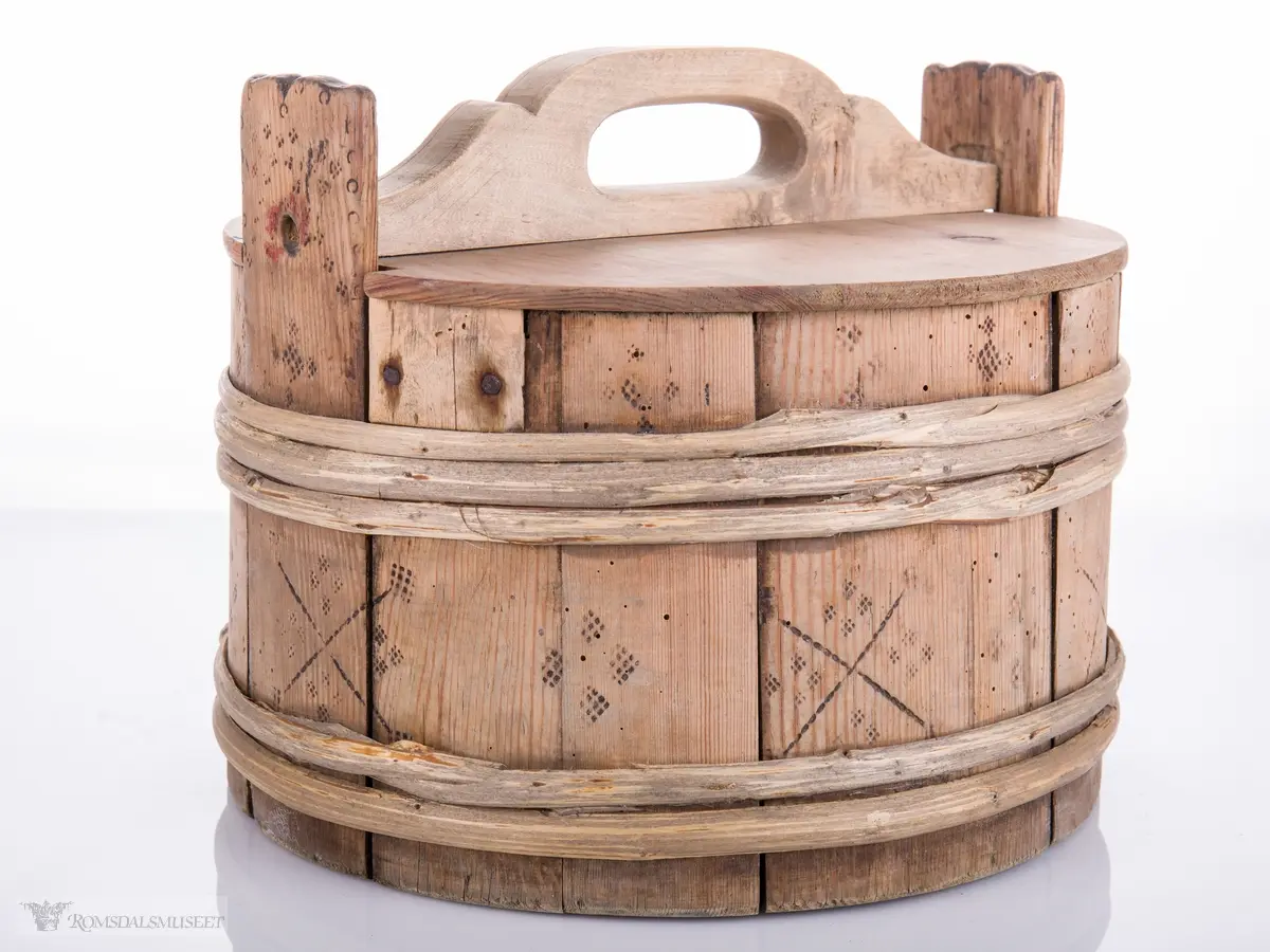 Lagget ambar med ører og lokk med hanke. Omslått med gjorder oppe og nede.