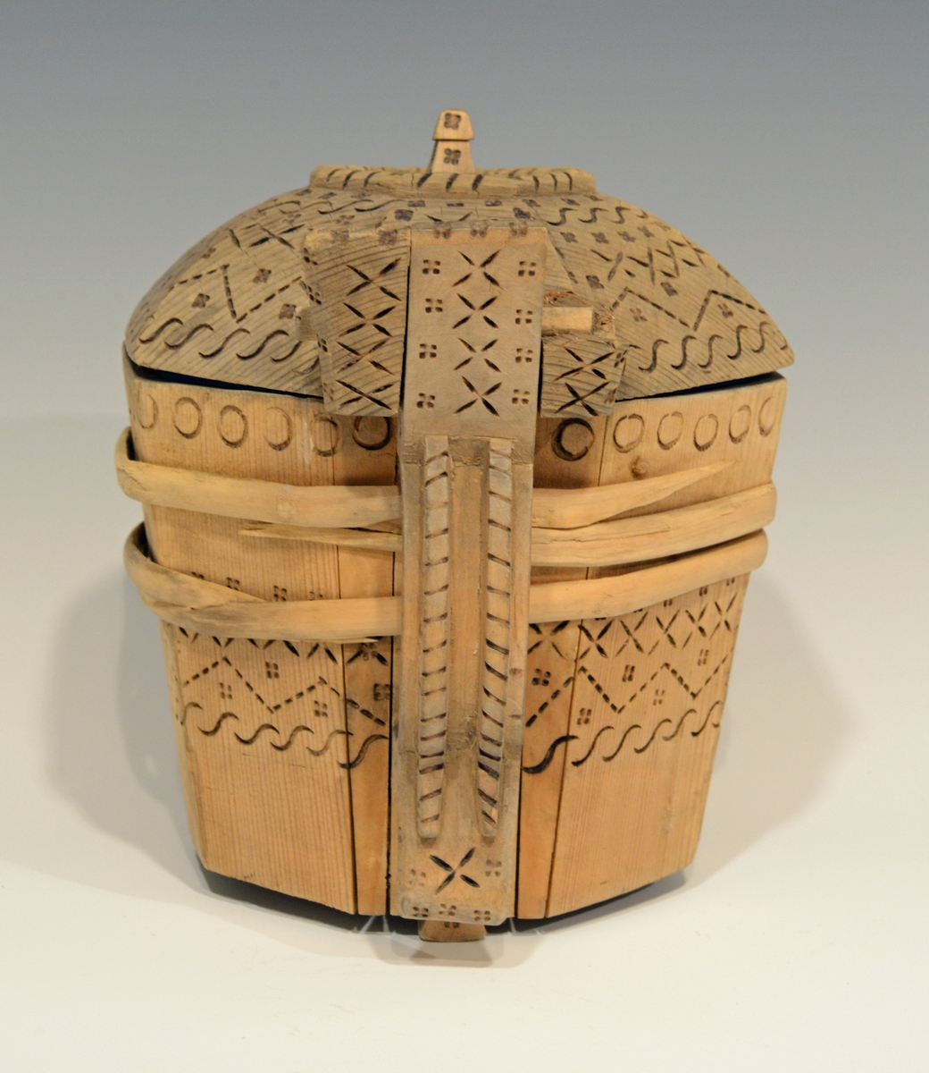 Fra katalog: Ottekantet smørkande og stav med hank og laak og tre smaa føtter, utvendig svimerket og en slynget ring oppe paa laaket, indvendig
rik rosette. Under staar brændemerket: A OSS 1823,