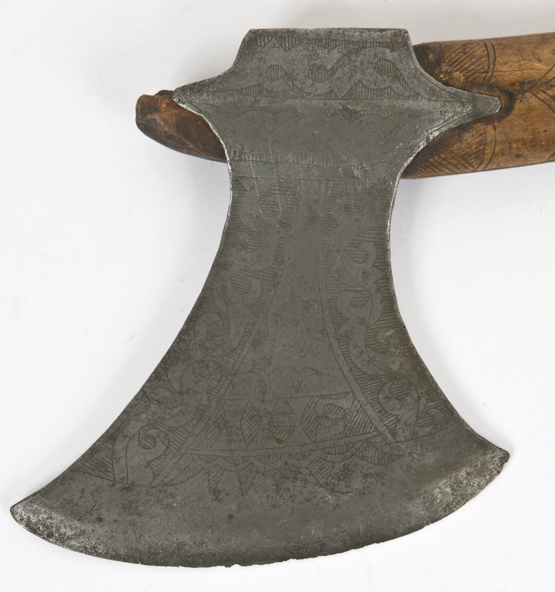 Asymmetrisk blad med lang øvre spiss og kortere nedre spiss.
Bladet er tynt, med påsmidd noe tykkere egg.
Øksehammeren har skaftehull og fliker.
Smedmerke formet som et skjell. Øksen har etset rankedekor på begge sider.
Skaftet er svakt krummet. Skaftet er merket på ryggen S 1683 .Skaftet har skåret dekor i felter. Skaftet har jernring nede.