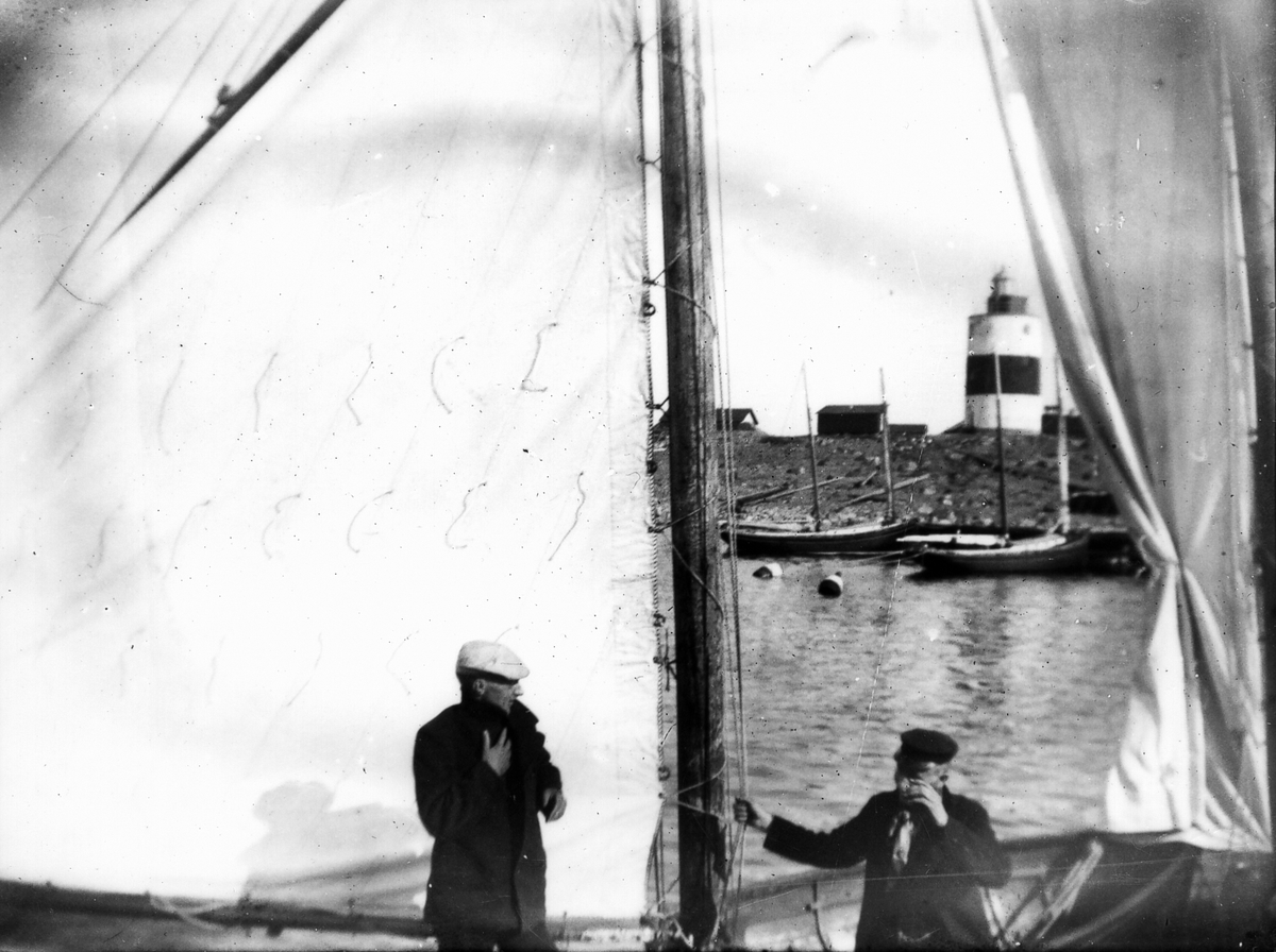 Två män ombord på segelskuta.