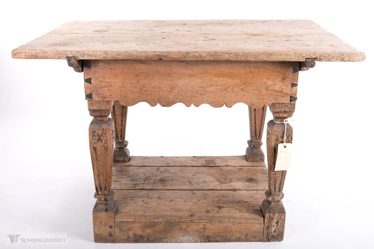 Platen hviler på arkitrav som igjen hviler på koniske pillarer med en form for kannelering med kapitel/terningkapitel og basis. Alt hviler på postamentet med høyde 12 cm.