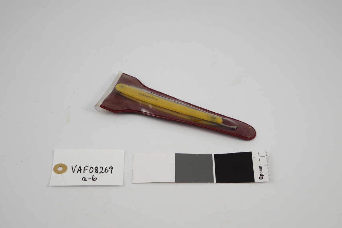 a) Rektangulær kniv, innhukk og smalere flate mot festet. Håndtak: to deler festet m/to skruer, ovale, noe buet form. Kniven kan vris inn mellom disse delene. 
b) Futeral, transparent på den ene side , buet, langstrakt form.