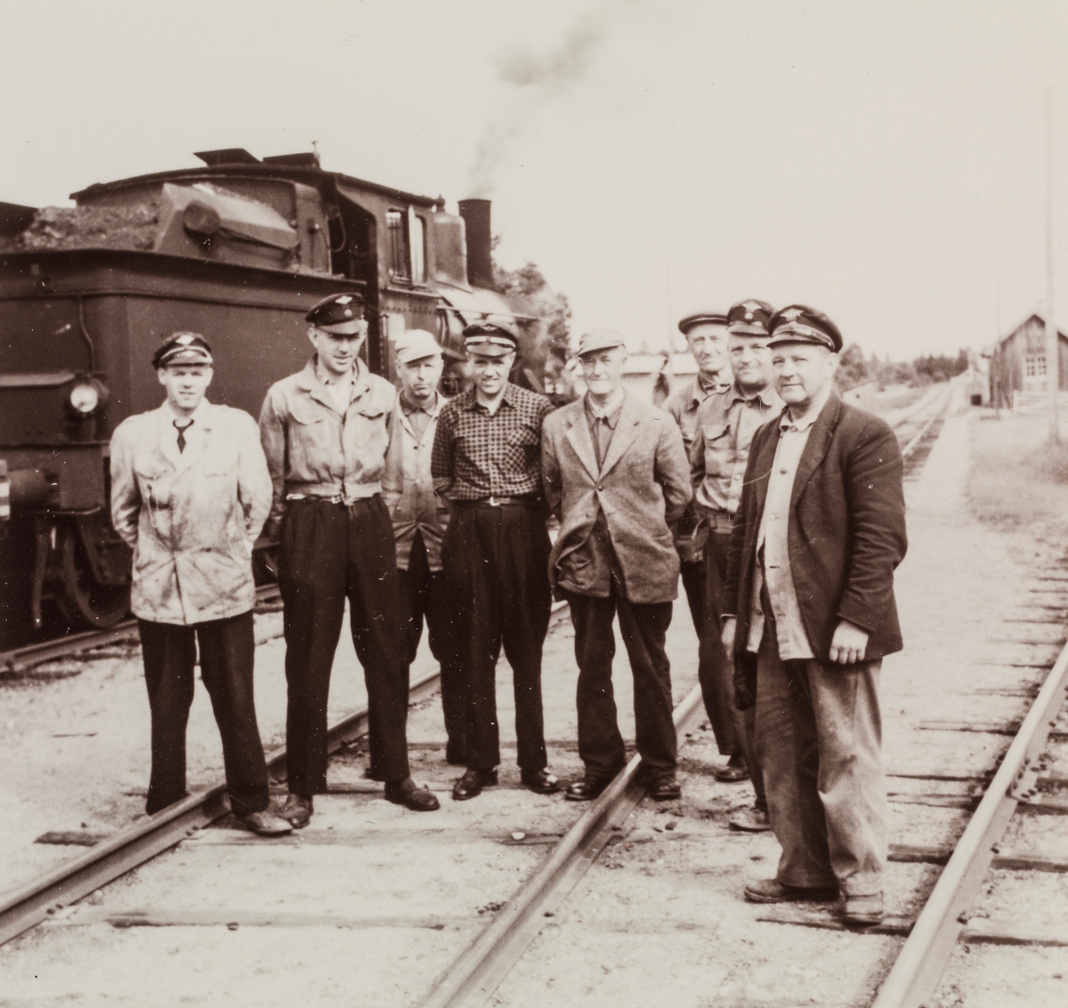 Jernbanepersonale på Vestmarkalinjen. I bakgrunnen damplokomotiv type 21.