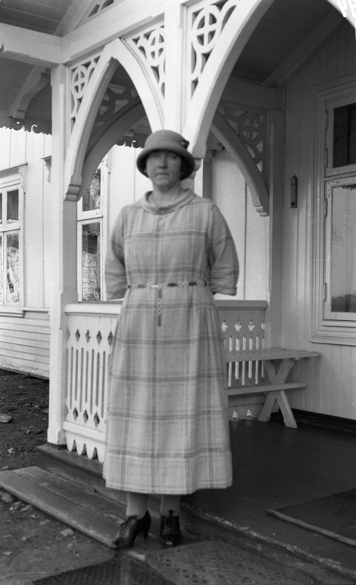 Uidentifisert kvinne og mann foran et våningshus. Fire bilder. På et er kvinnen alene, ellers de to sammen.