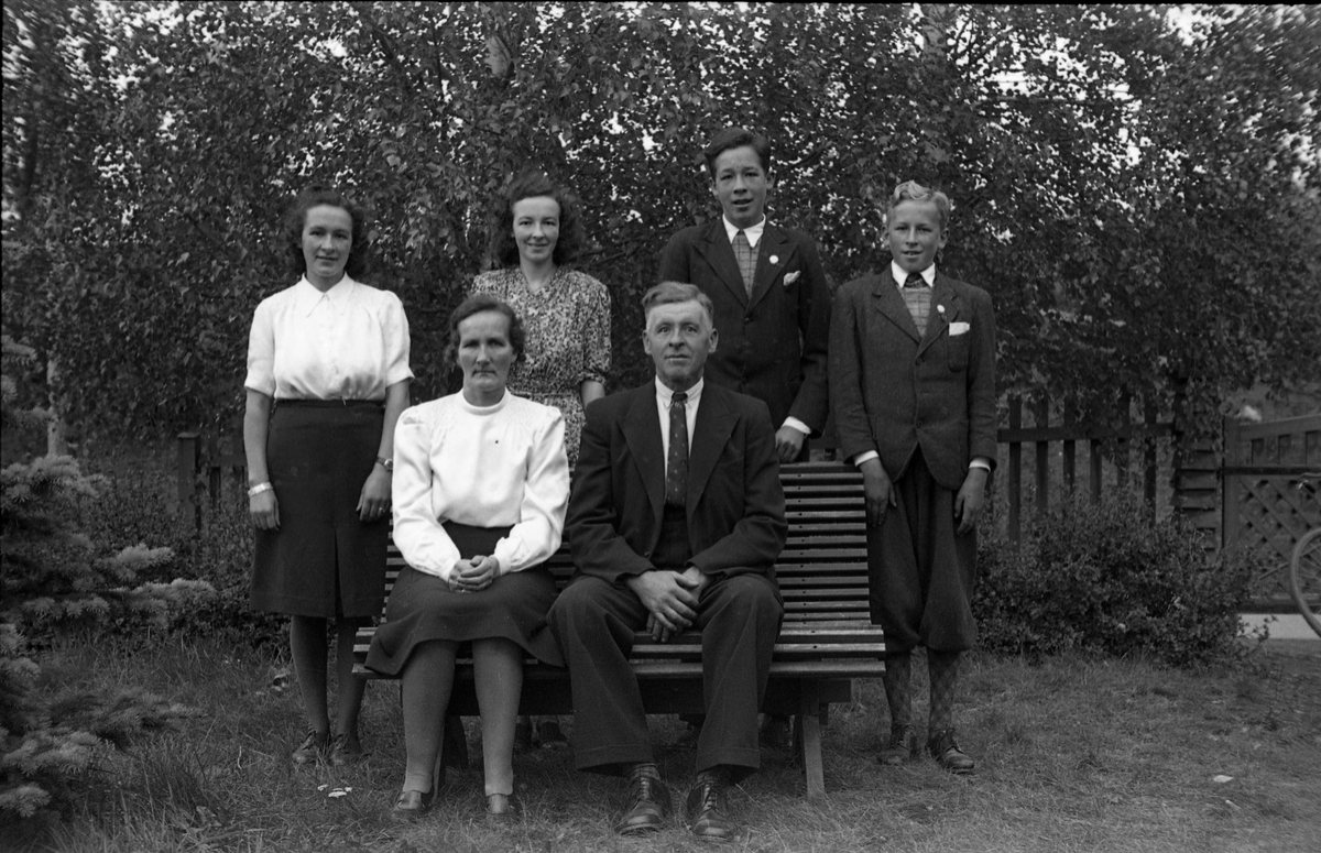 Familieportrett av Marit og Gustav Adolf Petterson som sitter foran, og sønner og døtre som står bak. Med bilde nr. en som referanse: Lengst til venstre står dattera Borghild Serine, guttenes fornavn er hhv. Gustav Adolf og Oddvar, men det er uklart hvem er hvem, mens fornavnet til dattera i hvit bluse er ukjent.