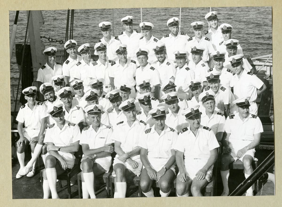Bilden föreställer ett grupporträtt där minfartyget Älvsnabbens officerare och underofficerare i sommaruniform är samlade på livbåtsdäck under långresan 1966-1967.