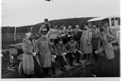 Gruppebilde av Divisjonsmusikken med to biler.