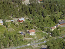 Øyer, Tretten. Gult, enetasjes hus med rødt tak og kjøkkenha