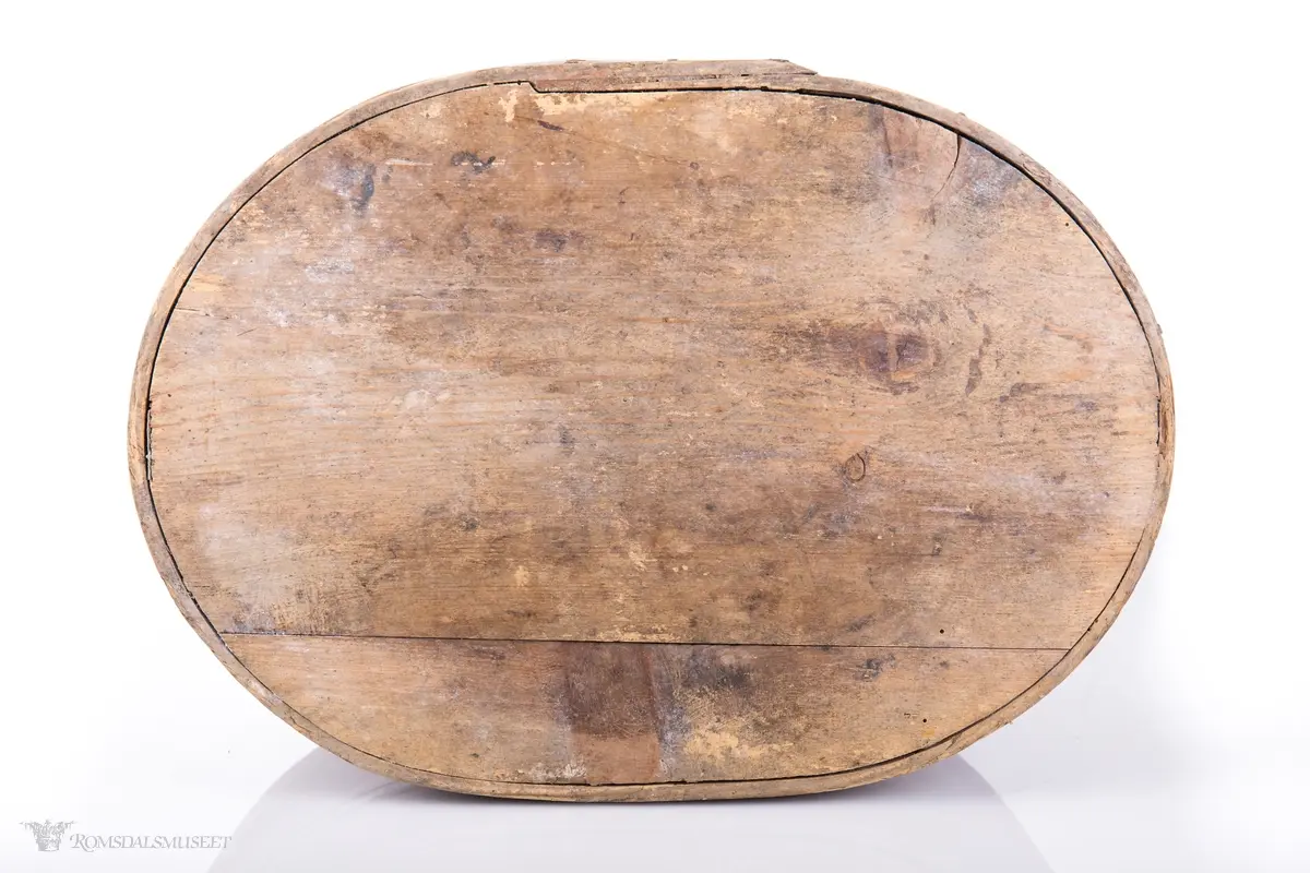 Hvite linjer langs kanten. Avrundet lokk. Innskrift.