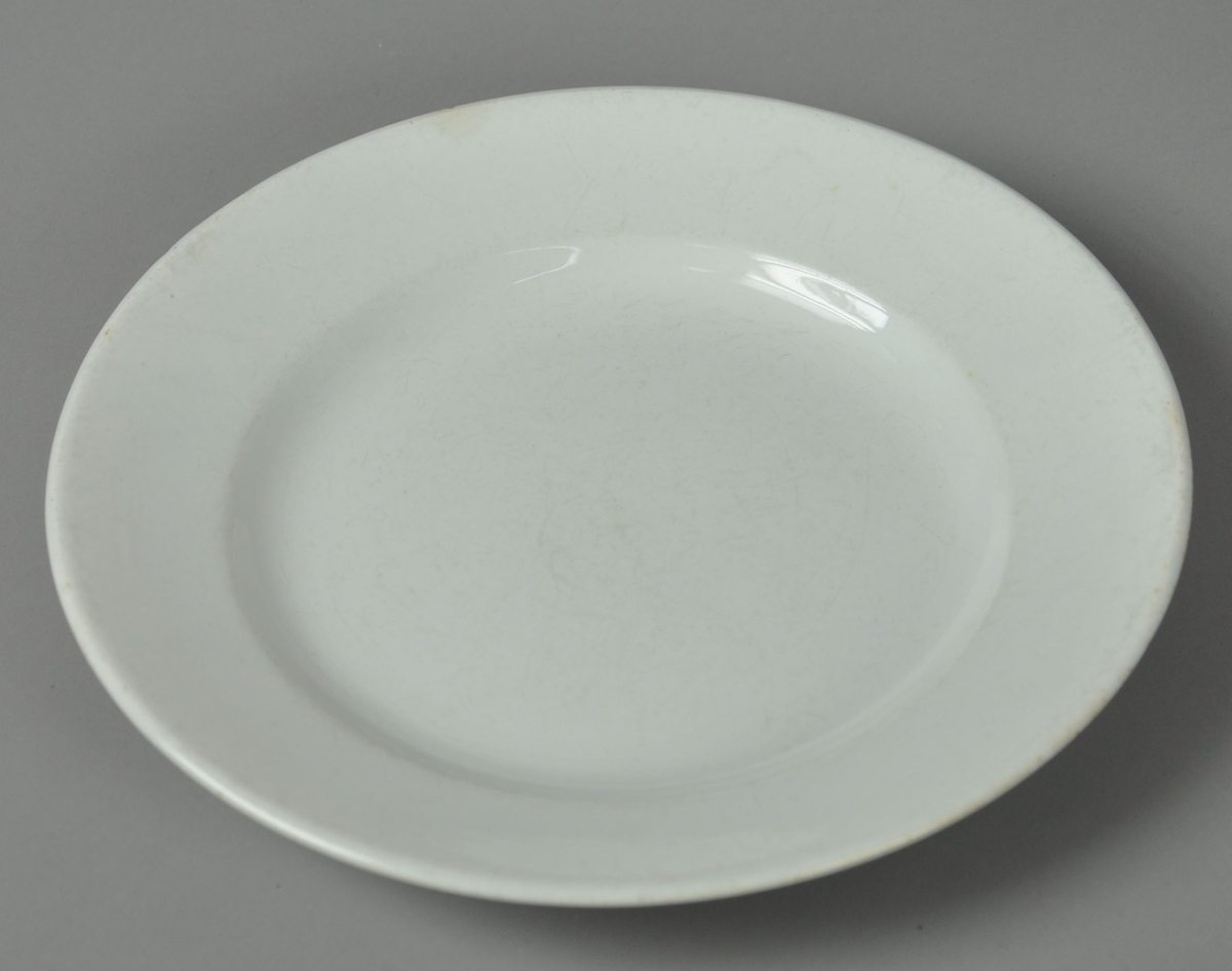 Hvit tallerken av glassert keramikk.