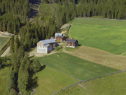 Øyer, Nord-Tretten. Skogli gård. Stor, umalt driftbygning me