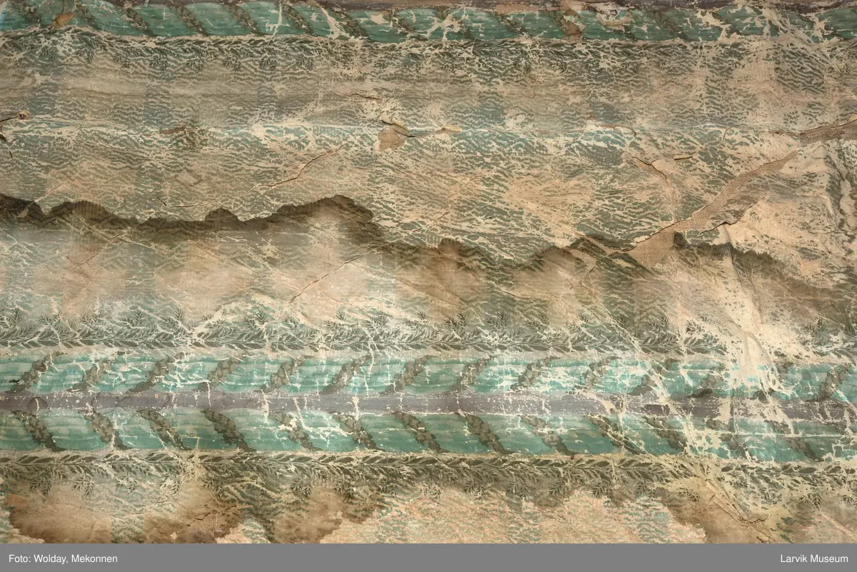 |Tapeten er påmalt tapetborder og brystning. Fra Hovland gård i Larvik.
Den øverste, brede borden: Gerlander/draperi med blomsterranker.
Den nederste, smalere borden: Tekstilbord med blomster. Øver døren til høyre: Stillebenmotiv med blomster og frukt.