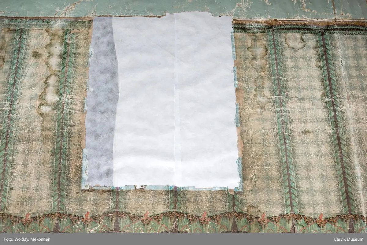 |Tapeten er påmalt tapetborder og brystning. Fra Hovland gård i Larvik.
Den øverste, brede borden: Gerlander/draperi med blomsterranker.
Den nederste, smalere borden: Tekstilbord med blomster. Øver døren til høyre: Stillebenmotiv med blomster og frukt.