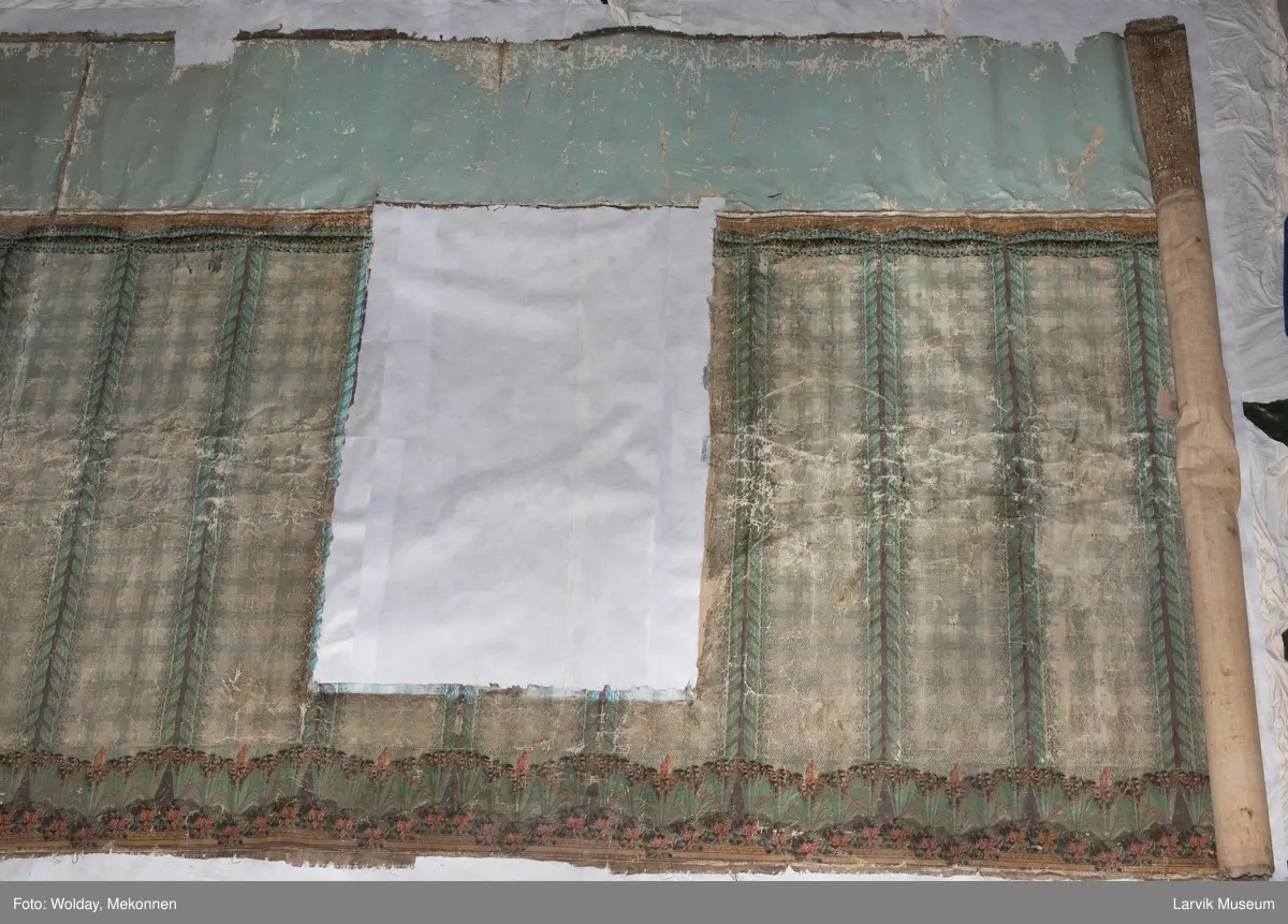 |Tapeten er påmalt tapetborder og brystning. Fra Hovland gård i Larvik.
Den øverste, brede borden: Gerlander/draperi med blomsterranker.
Den nederste, smalere borden: Tekstilbord med blomster. Øver døren til høyre: Stillebenmotiv med blomster og frukt.