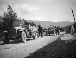 Mennesker i åpene biler stoppet på veg.