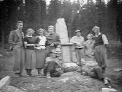 Gruppe menn og kvinner ved Per Gynt steinen på Fagervoll, So