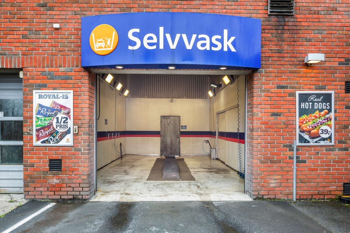 Statoil Nadderud. Åpen inngangsport til Selvvask. Vaskehallen ses innenfor. Reklame på veggen på begge sider av inngangsporten.