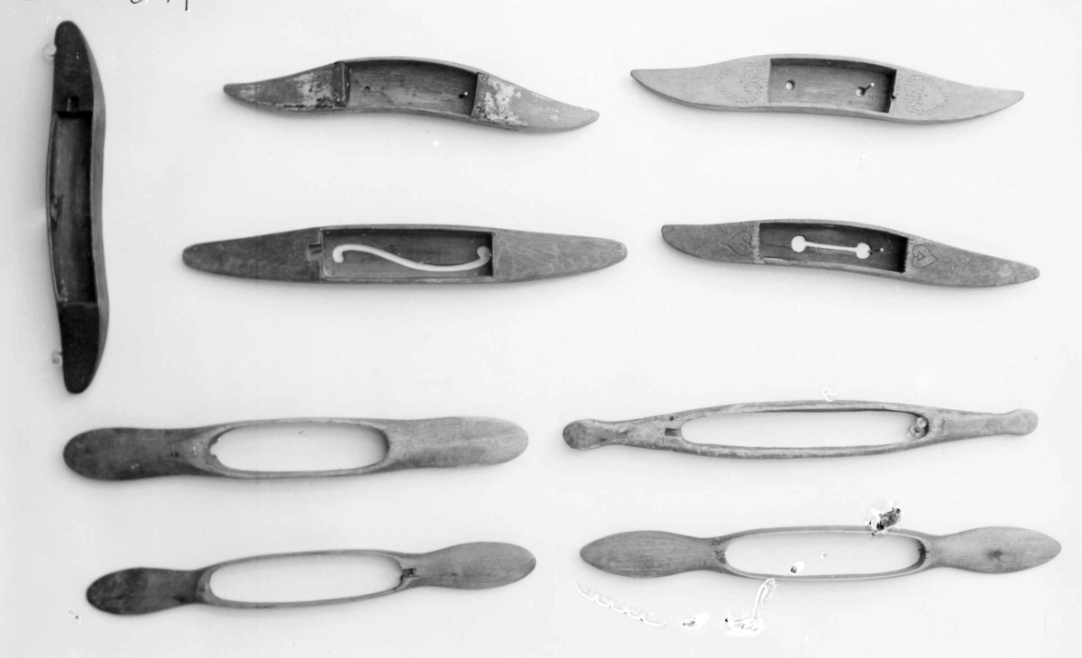 Avlang vevskyttel av tre med uthuling på midten, der hullet i bunnen er formet som en ranke.