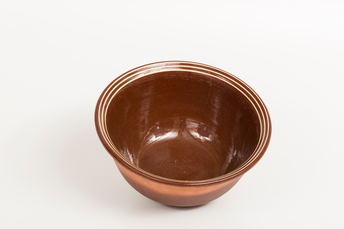 Brun bolle i keramikk med 3 gule striper. Glasert på innside.