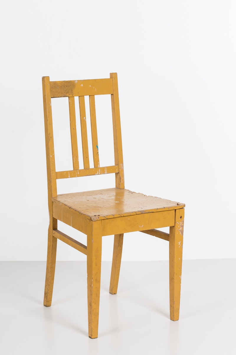 Stol i treverk, malt. Rygg med spiler. Den ene stolen har vært brukt betydelig røffere enn den andre.