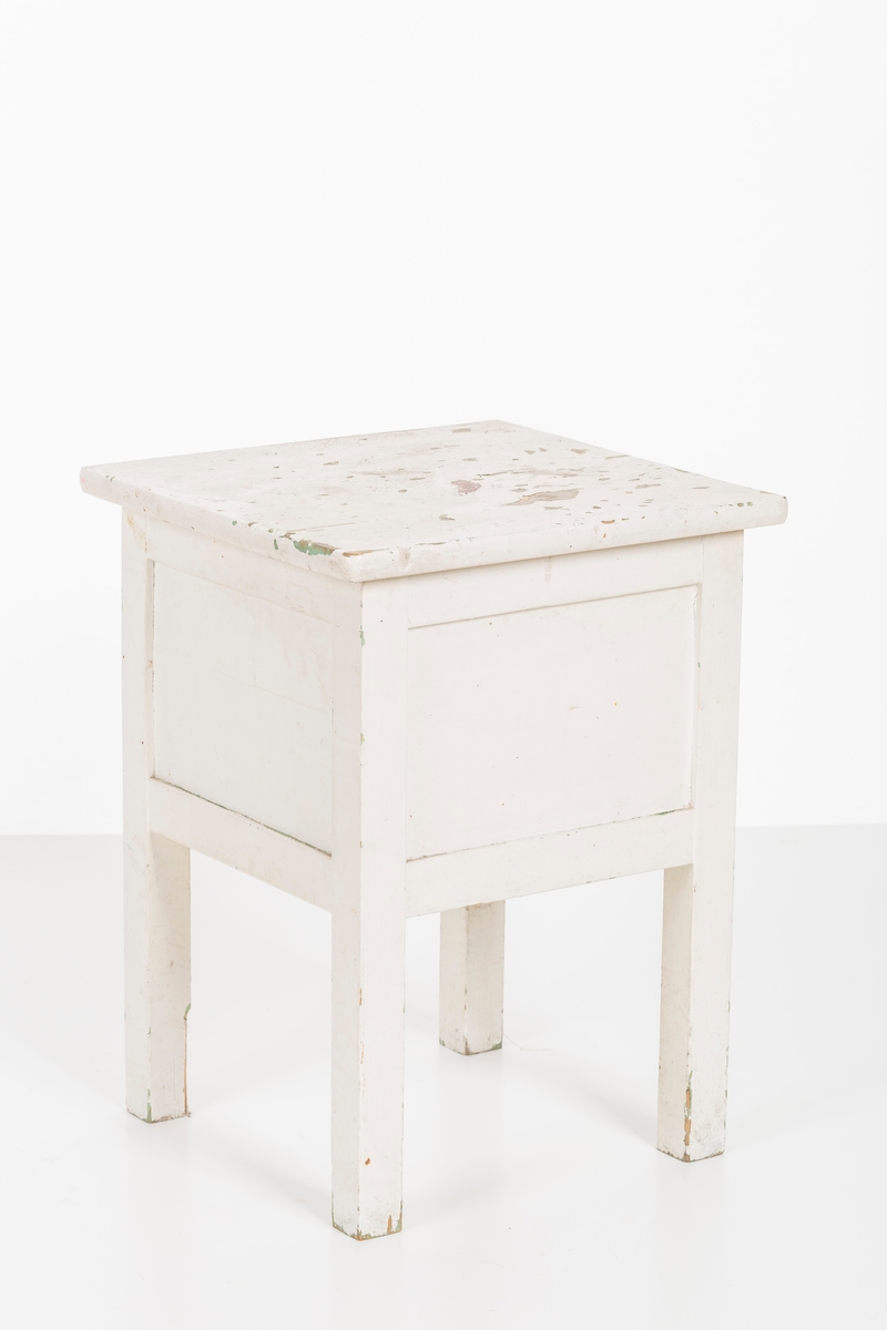 Hvitmalt krakk med oppbevaringsrom. Åpnes fra oversiden.