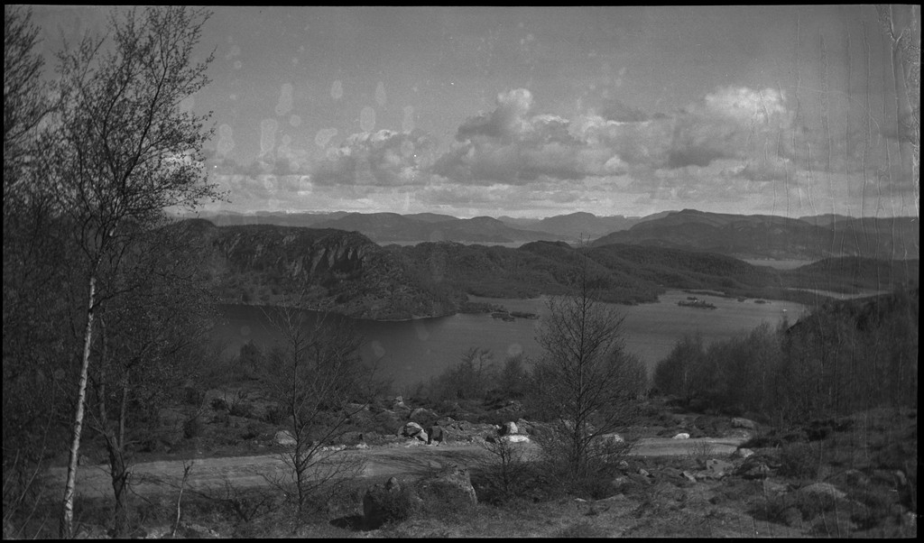 Harald Bergsaker og fotografen besøker flere små gårdsbruk og bygder i Strand kommune. Det er bilder fra landskap, bebyggelse, barn, sauer og lam. Frukttrærne står i full blomst.