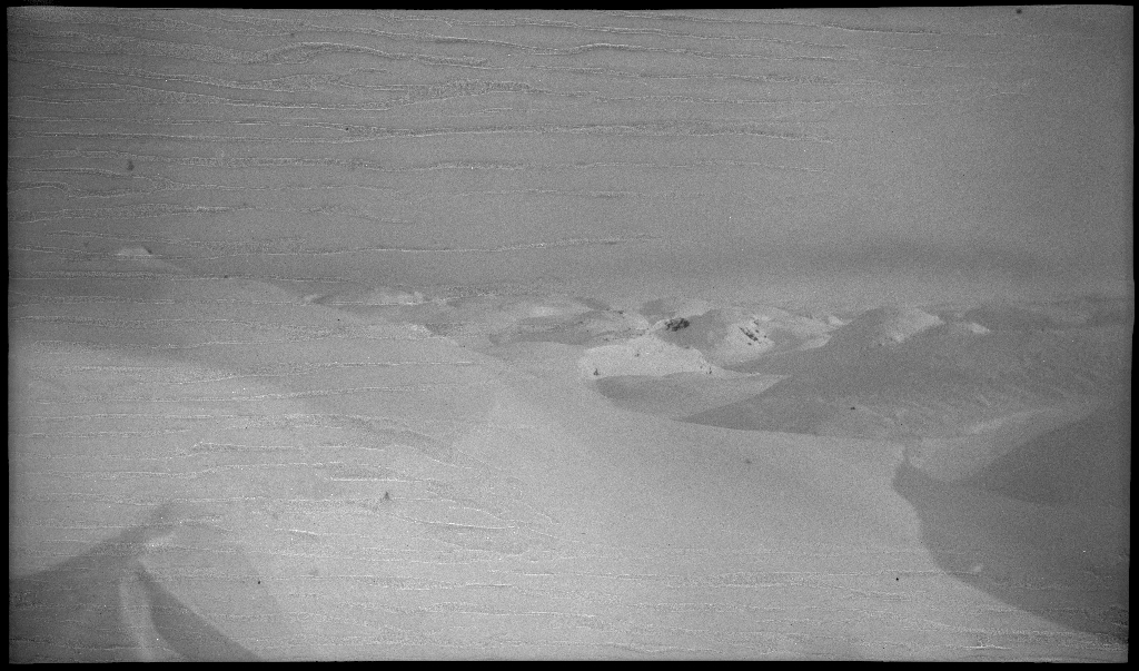 Fire unge menn på skitur fra Roalkvam til Stranddalen i Suldal. Det er bilder av hytter i fjellet, fra landskapet, lek med en hoppbakke og fra skigåing.