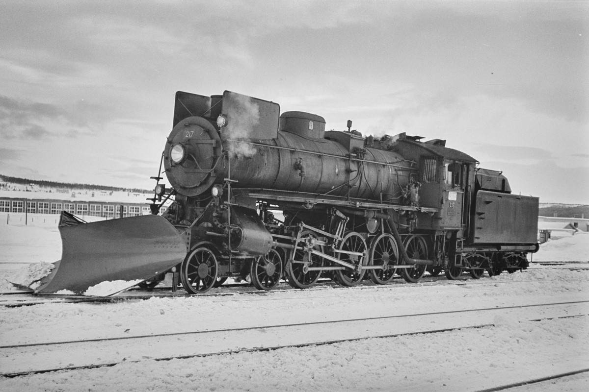 Damplokomotiv type 26a nr. 217 med stor frontplog på Røros stasjon.