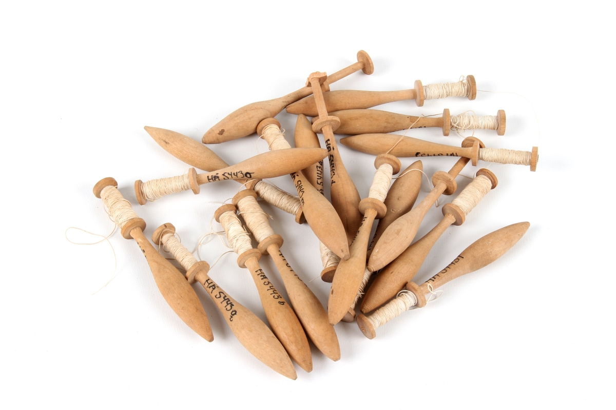 Atten ganske like kniplepinner i tre. De fleste med tråd og noen få uten.