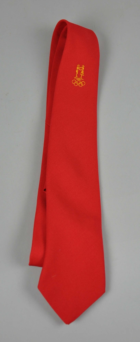 Rødt slips  med NOK/NIFsin  logo og de olympiske ringene påbrodert i sennepsgult.To like.