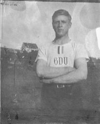 Soldat i t-skjorte med teksten "6DU". Generalboligen i bakgr