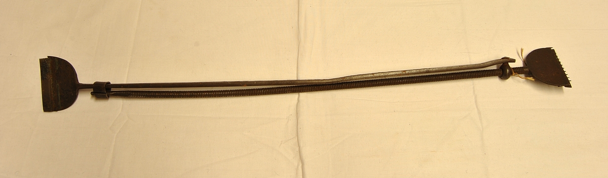 Avlan i form. To Jernstykker som er festet i hverandre. Spadeform med pigger på i hver ende. Gjenger på det ene lange jernstykket.