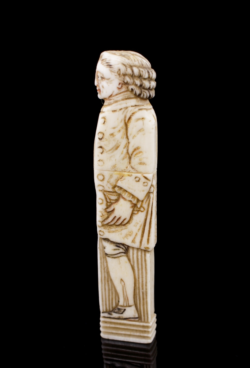 Nåletui, av ben.
Snidad och ristad dekor I form av en mansfigur i 1700-talskläder.
Saknar signatur/stämplar.
Svensk eller möjl. engelsk tillverkning.
