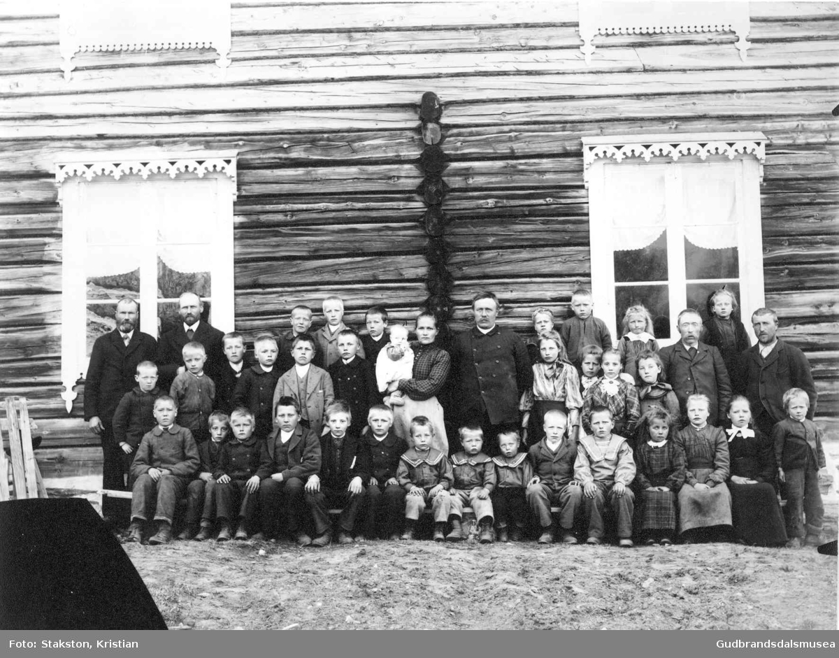 Elevar, lærar og tilsyn ved Lindsheim skule fotografert ved klokkargarden Skogheim
