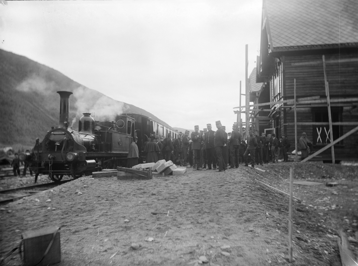 Togsett med lokomotiv Damplok type 1 med vogner på Otta stasjon. Mange personer med jernbaneunifor og andre personer. Før åpning av Otta staion.