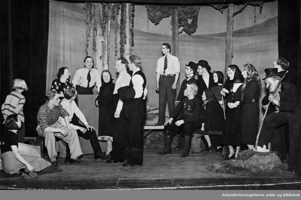 Oslo Arbeiderteater, Samfundsteatret. En scene fra Reinert Torgeirsons skuespill "Jonsokfest" fra 1939. Stykket, som var en komedie i 4 akter, hadde premiere 1. mai 1939. Fra v. bl.a.: Rudaa, Bjørn; Braude, Harry; Rudaa, Signe; Andresen, Hartvik; Pettersen, Stein; Kirkenær, Even Torgeirson, Reinert (forf.).